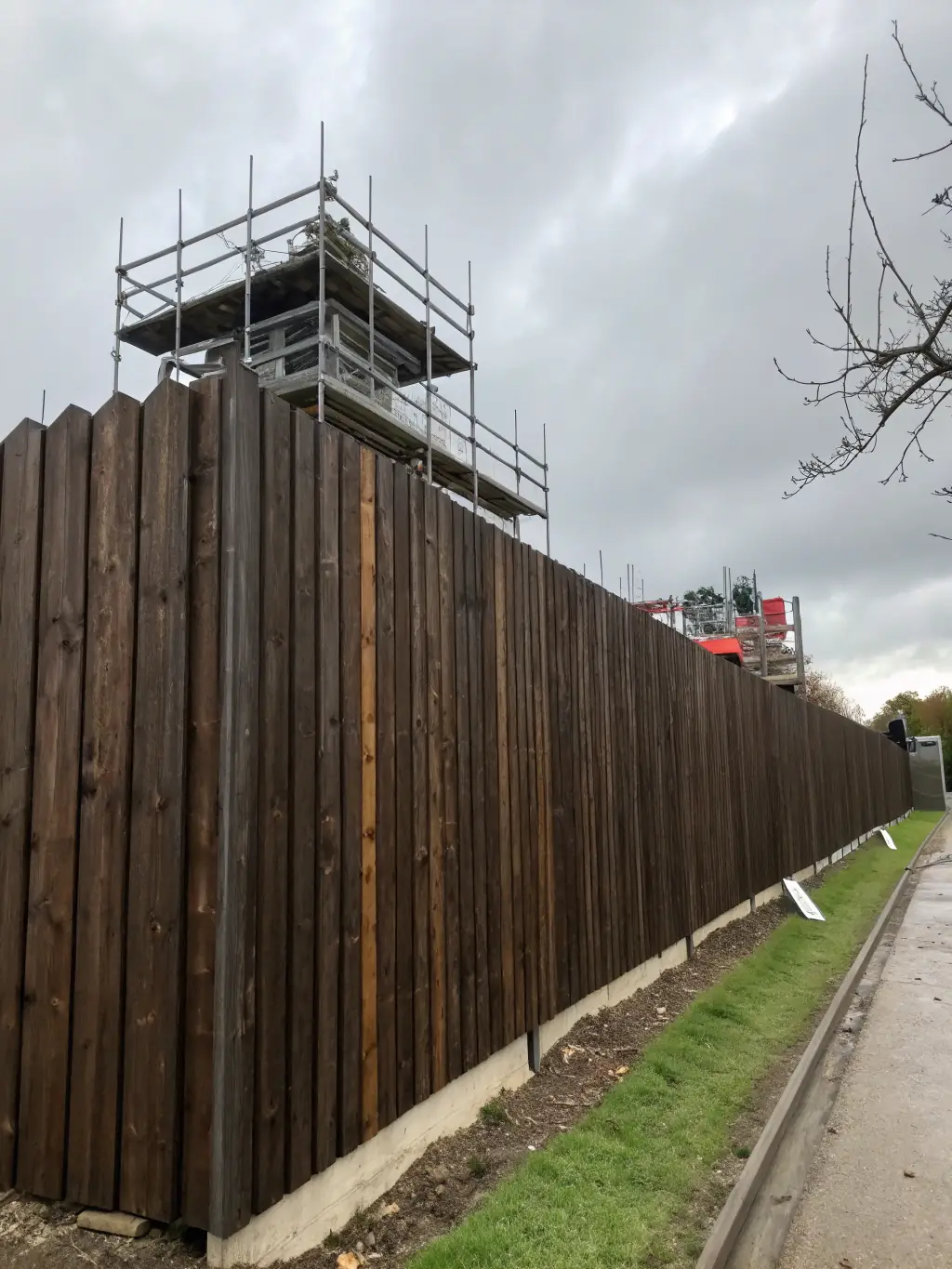 A tall wooden privacy fence enclosing a construction site, ensuring privacy and safety.